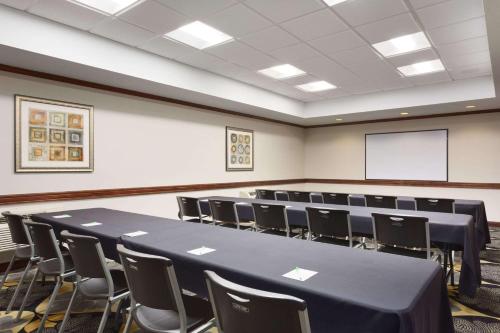 a conference room with a table and chairs and a screen at Wyndham Garden Grand Rapids Airport in Grand Rapids