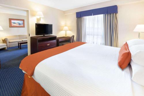 a hotel room with a large bed and a flat screen tv at Wyndham Garden Monterrey Norte in Monterrey