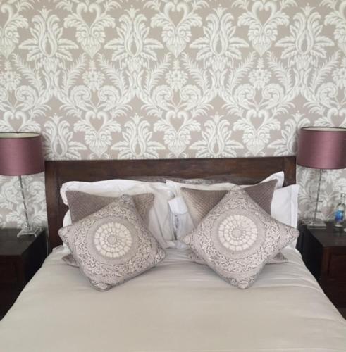 a bedroom with a bed with pillows and a wallpaper at The Hambrough in Ventnor