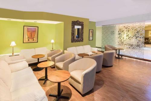 a waiting room with white chairs and tables at Wyndham Garden Obregon in Ciudad Obregón