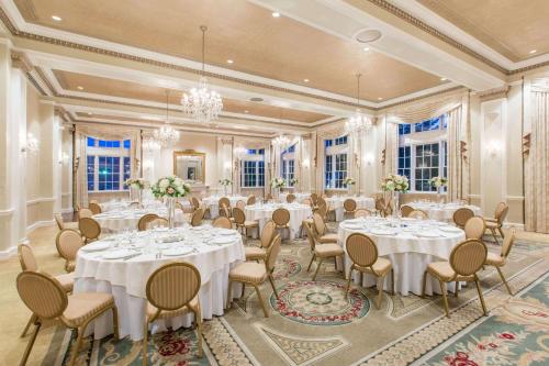 a banquet room with white tables and chairs at The George Washington - A Wyndham Grand Hotel in Winchester