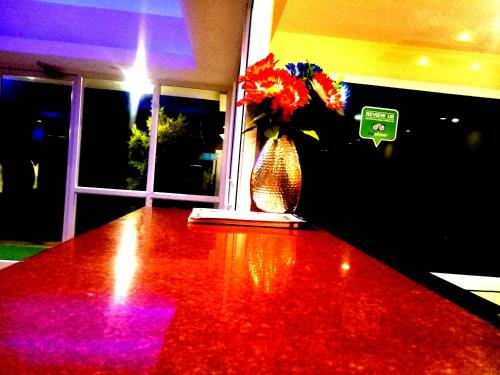 a vase with flowers on top of a table at Arra Suites kempegowda Airport Hotel in Devanahalli-Bangalore