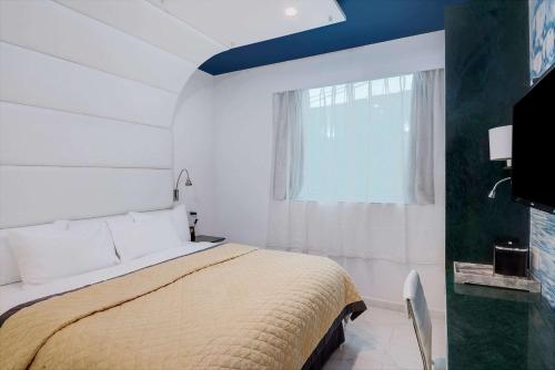 a white bedroom with a bed and a window at Wyndham Garden Brooklyn Sunset Park in Brooklyn
