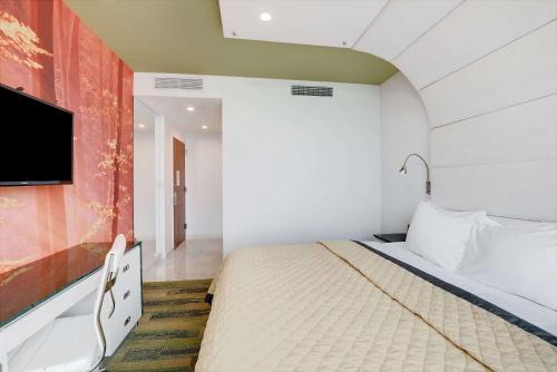 a bedroom with a bed and a flat screen tv at Wyndham Garden Brooklyn Sunset Park in Brooklyn