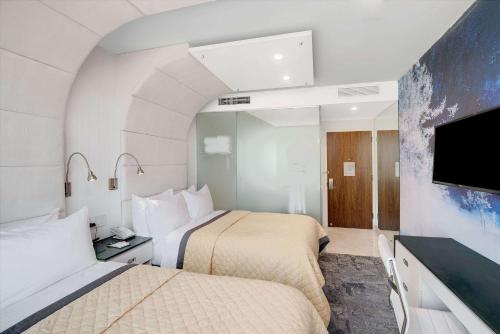 a hotel room with two beds and a flat screen tv at Wyndham Garden Brooklyn Sunset Park in Brooklyn