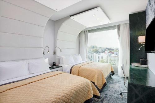 a hotel room with two beds and a window at Wyndham Garden Brooklyn Sunset Park in Brooklyn