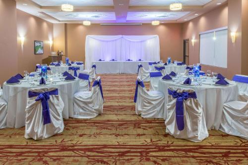 a banquet room with white tables with blue bows at Hotel 11, MOD A Sonesta Collection in Calgary