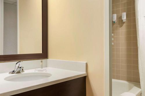 a bathroom with a sink and a mirror and a tub at Travelodge by Wyndham Sydney in Sydney