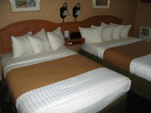 a hotel room with two beds and a night stand with at Pepper Tree Inn Tahoe City in Tahoe City