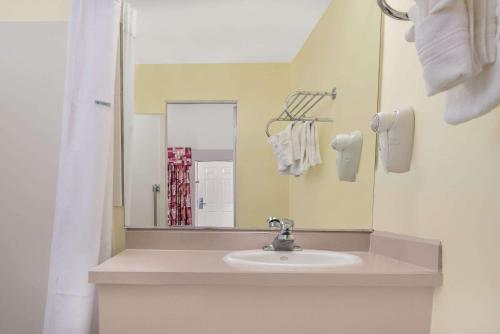 a bathroom with a sink and a mirror at Travelodge by Wyndham Klamath Falls in Klamath Falls