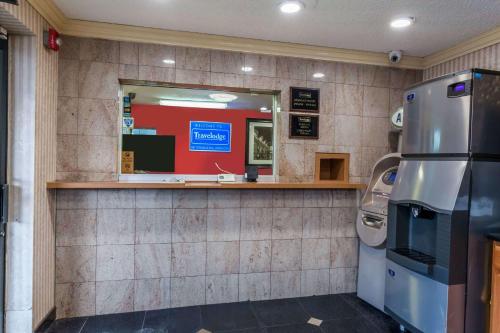 a restaurant counter with a mirror and a refrigerator at Travelodge by Wyndham Jersey City in Jersey City