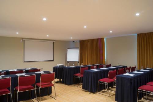 a conference room with red chairs and a screen at Alteza Polanco in Mexico City