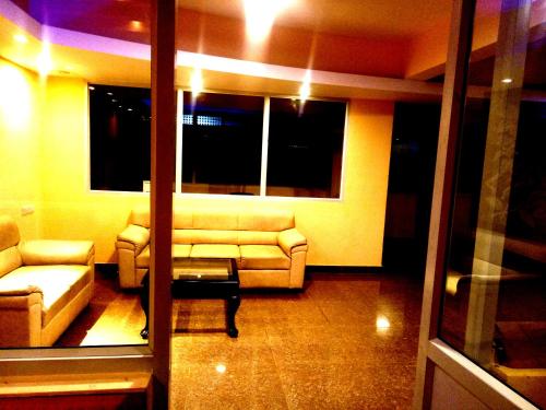 a living room with a couch and a table at Arra Suites kempegowda Airport Hotel in Devanahalli-Bangalore