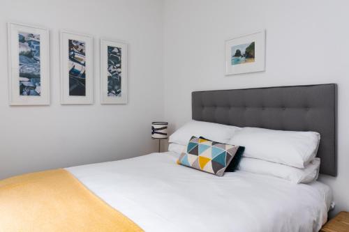 um quarto com uma cama branca e uma almofada em Tregenna Apartments em St. Ives