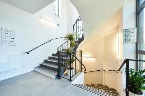a staircase in a house with potted plants at Le Manoir de Kerbot in Sarzeau