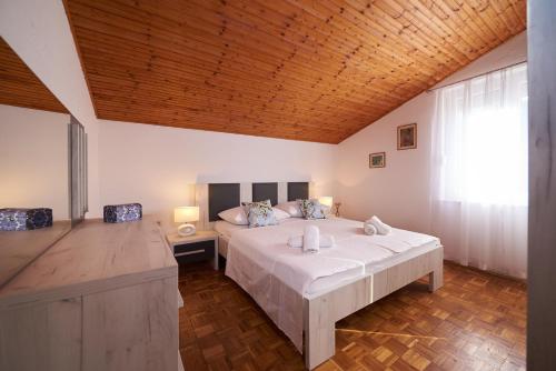 um quarto com uma cama grande e um tecto de madeira em Apartments Lara em Stobreč