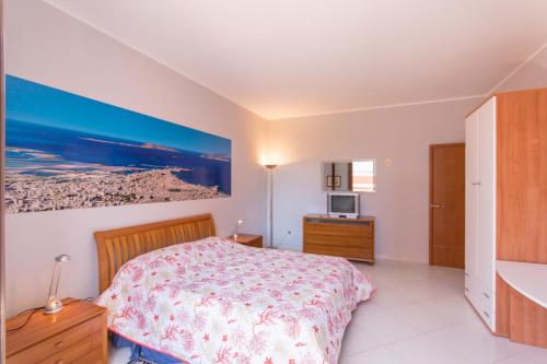 トラーパニにあるTerrazza Sul Mareのベッドルーム1室(ベッド1台付)が備わります。壁には絵画が飾られています。