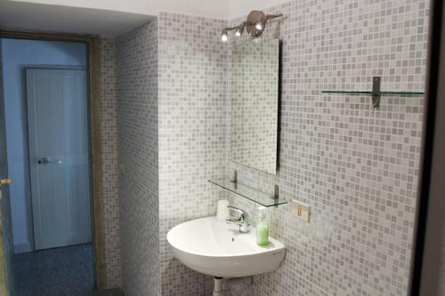 a white bathroom with a sink and a mirror at Bed & Bike Casa dei Papi in Portoferraio