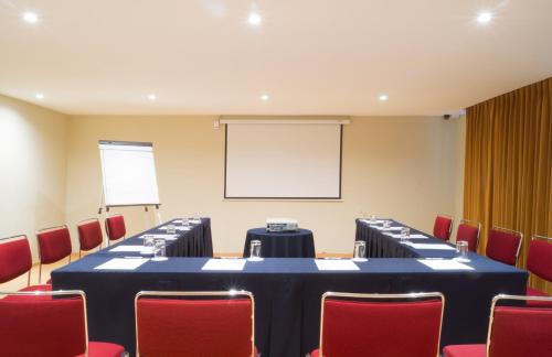 a meeting room with a long table and red chairs at Alteza Polanco in Mexico City