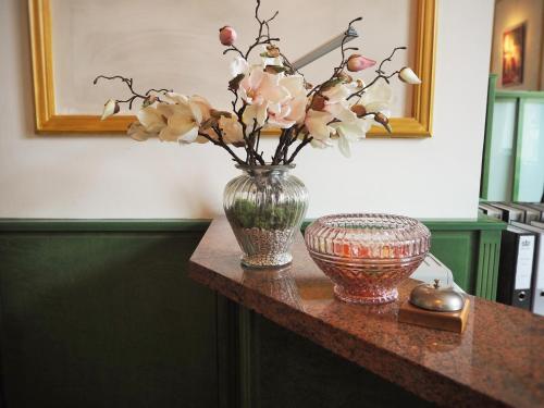 a table with a vase with flowers in it at Gala Hotel in Pforzheim