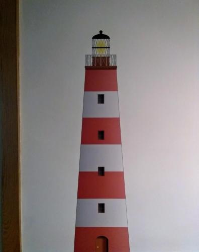 a red and white lighthouse sitting next to a wall at Aldatzeta Ostatua in Bermeo