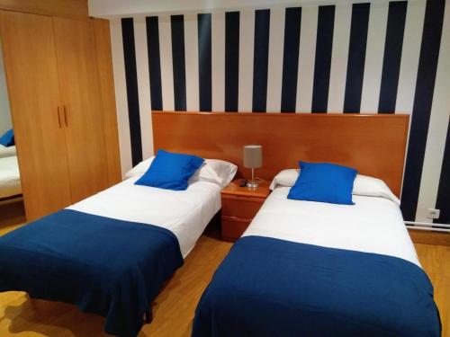 two beds sitting next to each other in a room at Aldatzeta Ostatua in Bermeo