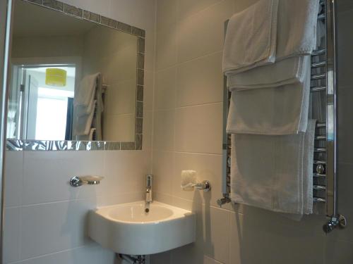 a bathroom with a sink and a mirror at Lazy Days B&B in Broadstairs