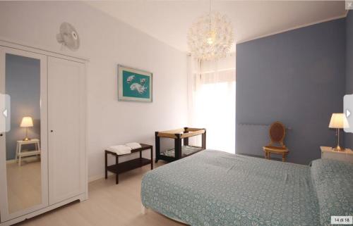 Un dormitorio con una cama y una lámpara de araña. en Casa Ilaria, en Viareggio