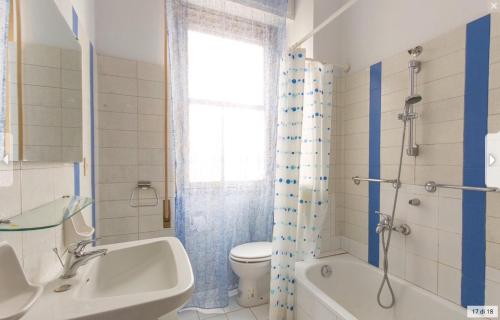 Un baño con bañera, inodoro y lavabo. en Casa Ilaria, en Viareggio