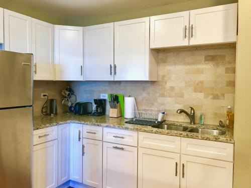 a kitchen with white cabinets and a sink at Laugh, Eat, Sleep Downtown Wine Down 9E in Atlanta