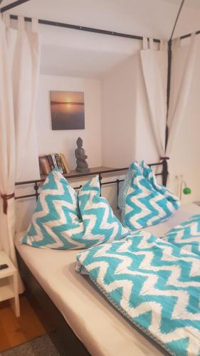 a bed with blue and white pillows on it at Hoamatl in Ebbs