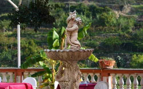 a statue of a woman and a squirrel in a fountain at Albergo Ristorante San Matteo in San Bartolomeo al Mare