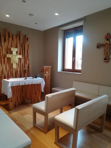 a room with a table and chairs and a cross on the wall at Hotel Il Cantico St. Peter in Rome