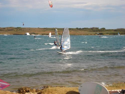a person windsurfing on the water at the beach at Apartments Villa Orange in Medulin