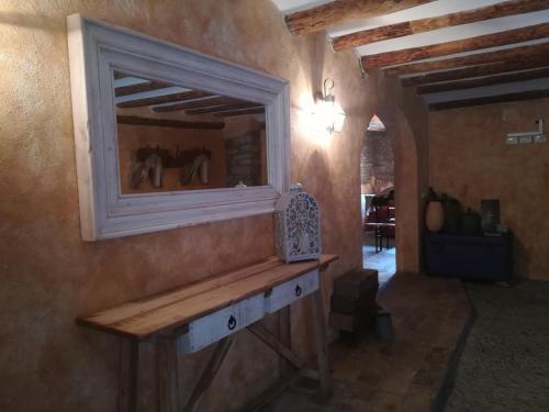 a room with a mirror on a wall with a bench at Casa el Francés in Graus