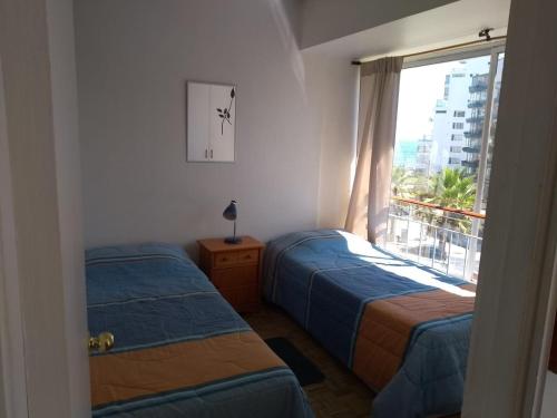 1 dormitorio con 2 camas individuales y ventana en Apartamento cerca del mar en Viña del mar, en Viña del Mar