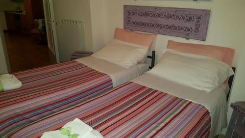 two twin beds in a room with a striped blanket at Agriturismo Podernuovo in Acquapendente