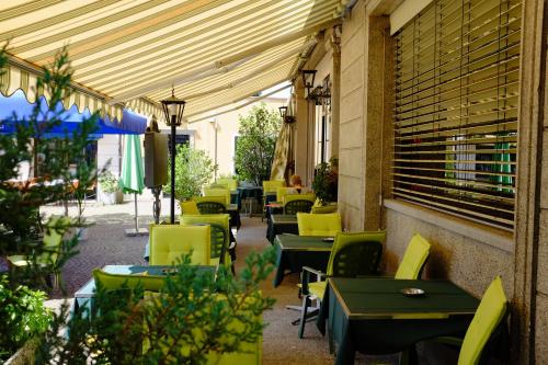 una fila de mesas y sillas en un restaurante en Hotel Corona en Locarno