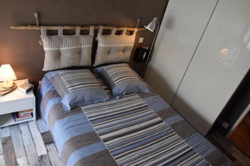 サンティレール・ド・リエにあるAuxmouettes GV2のベッド(枕2つ付)、ベッドの横にナイトスタンドが備わります。