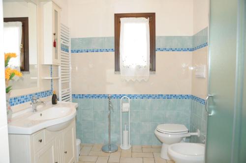 a bathroom with a toilet and a sink at B&B Ada in Torpè