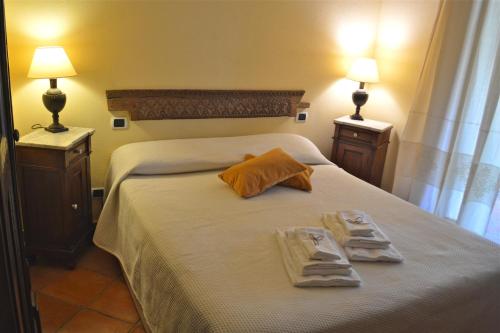 una camera da letto con un letto con due asciugamani e due lampade di Villa Charlie a Villasimius
