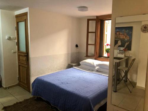 a bedroom with a blue bed and a window at Helen Apartment in Tel Aviv