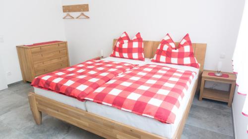 a bedroom with a bed with a red and white checkered blanket at Kogelschneiderhof in Dobl-Zwaring
