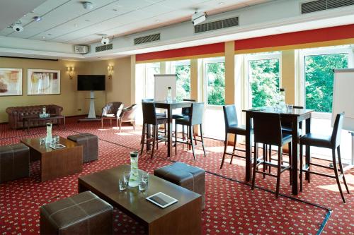a hotel room with tables and chairs in a room at Grand Hotel Gosforth Park in Newcastle upon Tyne