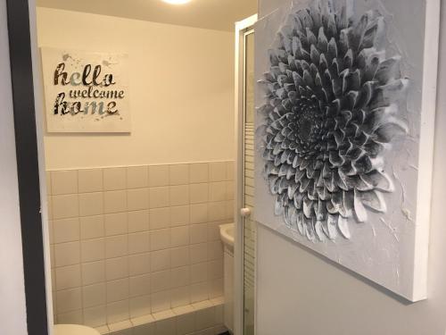 a bathroom with a flower painting on the wall at maison 4 personnes tout confort alentours boulogne sur mer in Samer