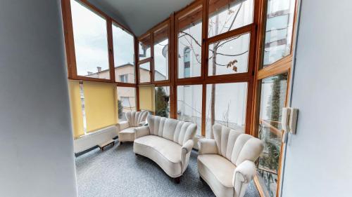 a room with a bunch of chairs and windows at Cluj Apartments in Cluj-Napoca