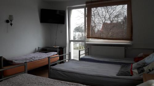 ウッチにあるNoclegi Pod Siódemkąの二段ベッド2台と窓が備わる客室です。