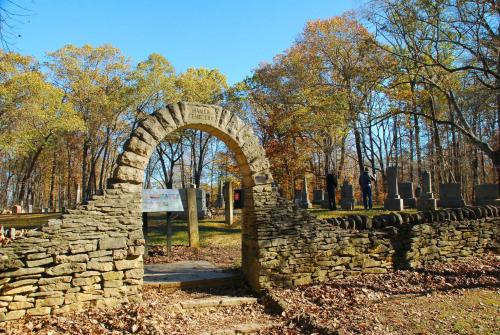 a stone arch in a cemetery with trees in the background at Spring Mill Inn in Mitchell
