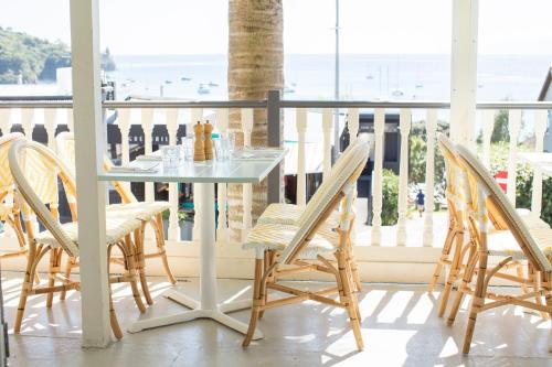 uma mesa e cadeiras numa varanda com vista para o oceano em The Oyster Inn em Oneroa