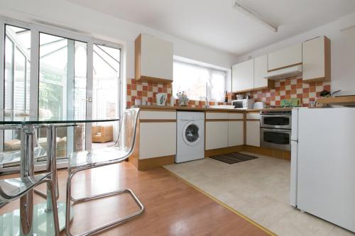 a kitchen with white appliances and a glass table at Yewdale House in Coventry